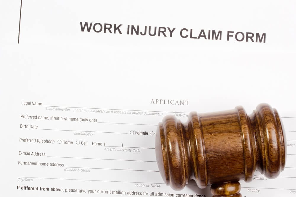 Close up of Work Injury Claim form and wooden gavel